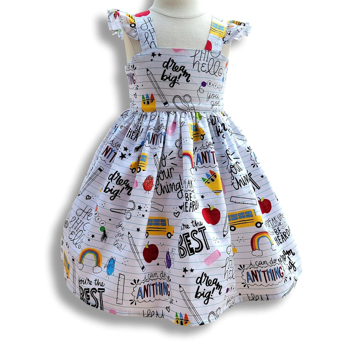 Children's dress with motivational text and graphics on a mannequin against a white background