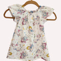 Children's dress with unicorn pattern on a hanger against a white background