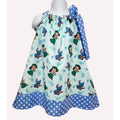 Children's dress with cartoon character print and polka dot trim on a white background