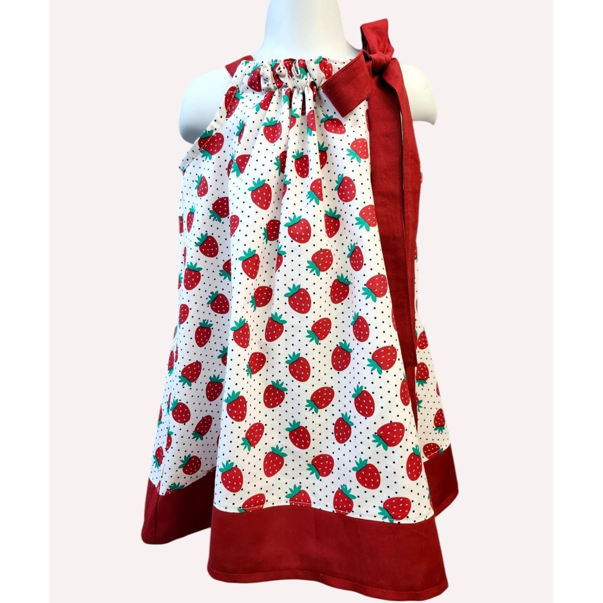 Dress with strawberry pattern on a mannequin against a white background