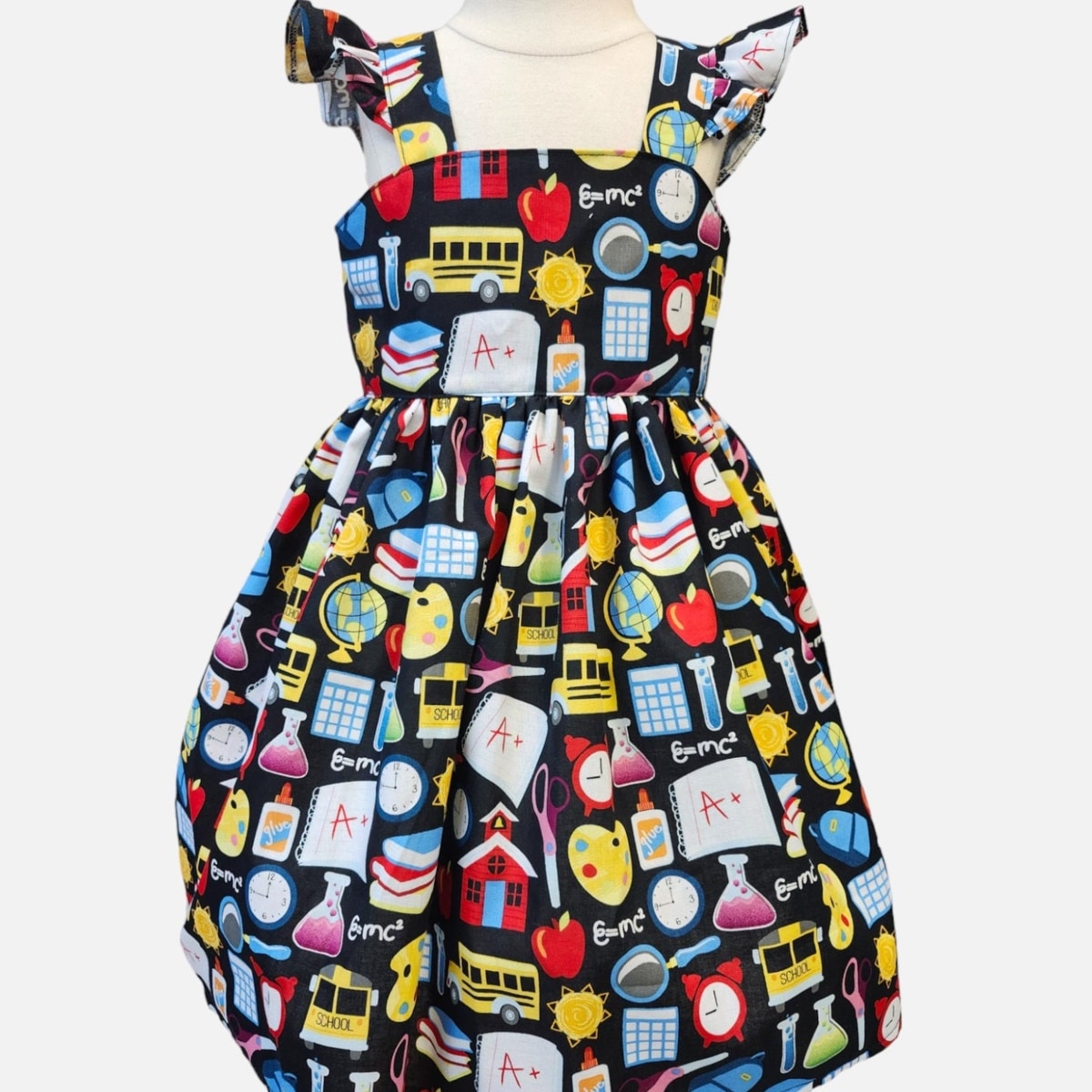 Children's dress with educational-themed print on a white background