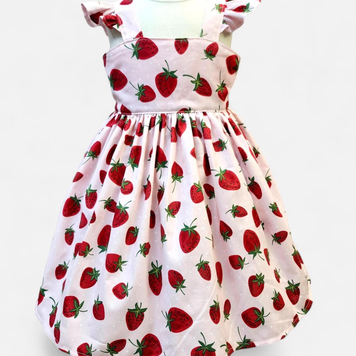 Children's dress with strawberry pattern on a white background