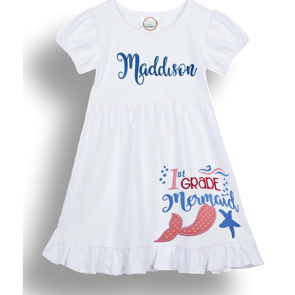 White dress with 'Maddison' and '1st Grade Mermaid' text, featuring a mermaid tail and starfish design.