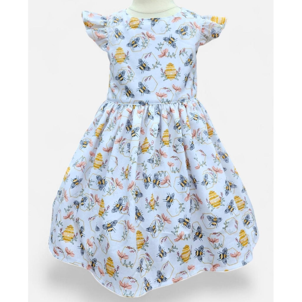 Children's dress with bee and flower pattern on a white background