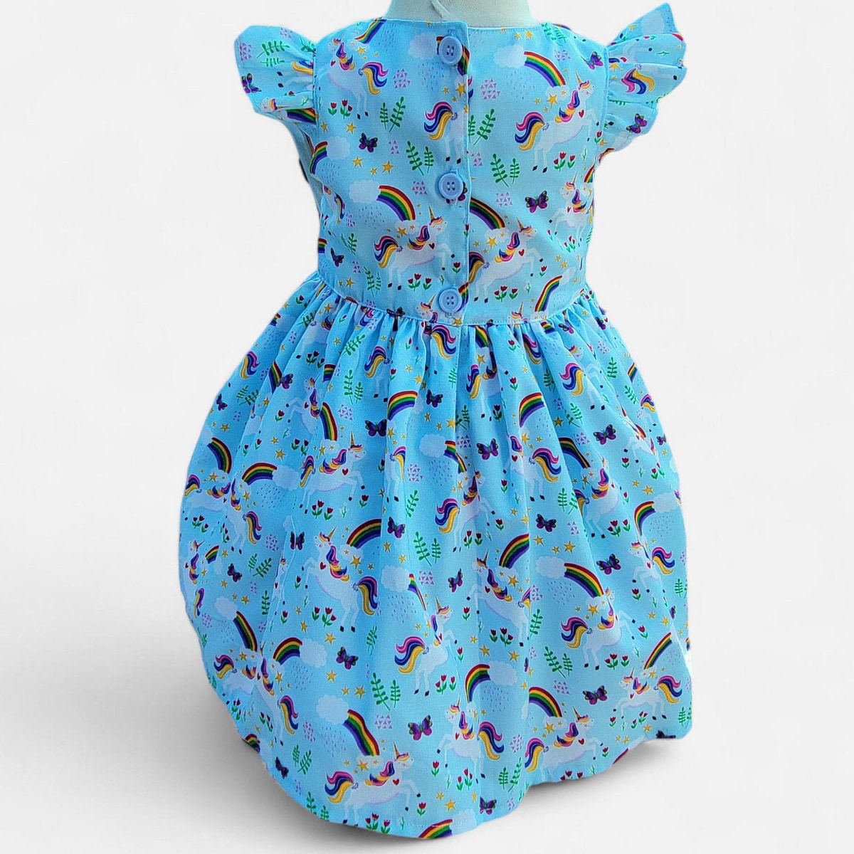Children's dress with unicorn and rainbow pattern on a blue background