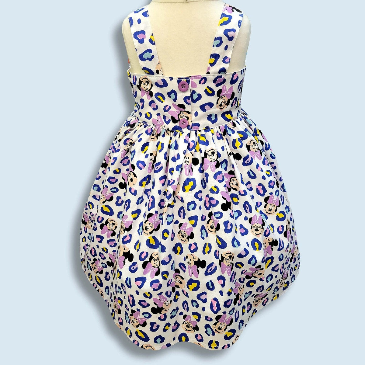 Dress with Minnie Mouse pattern on a light blue background