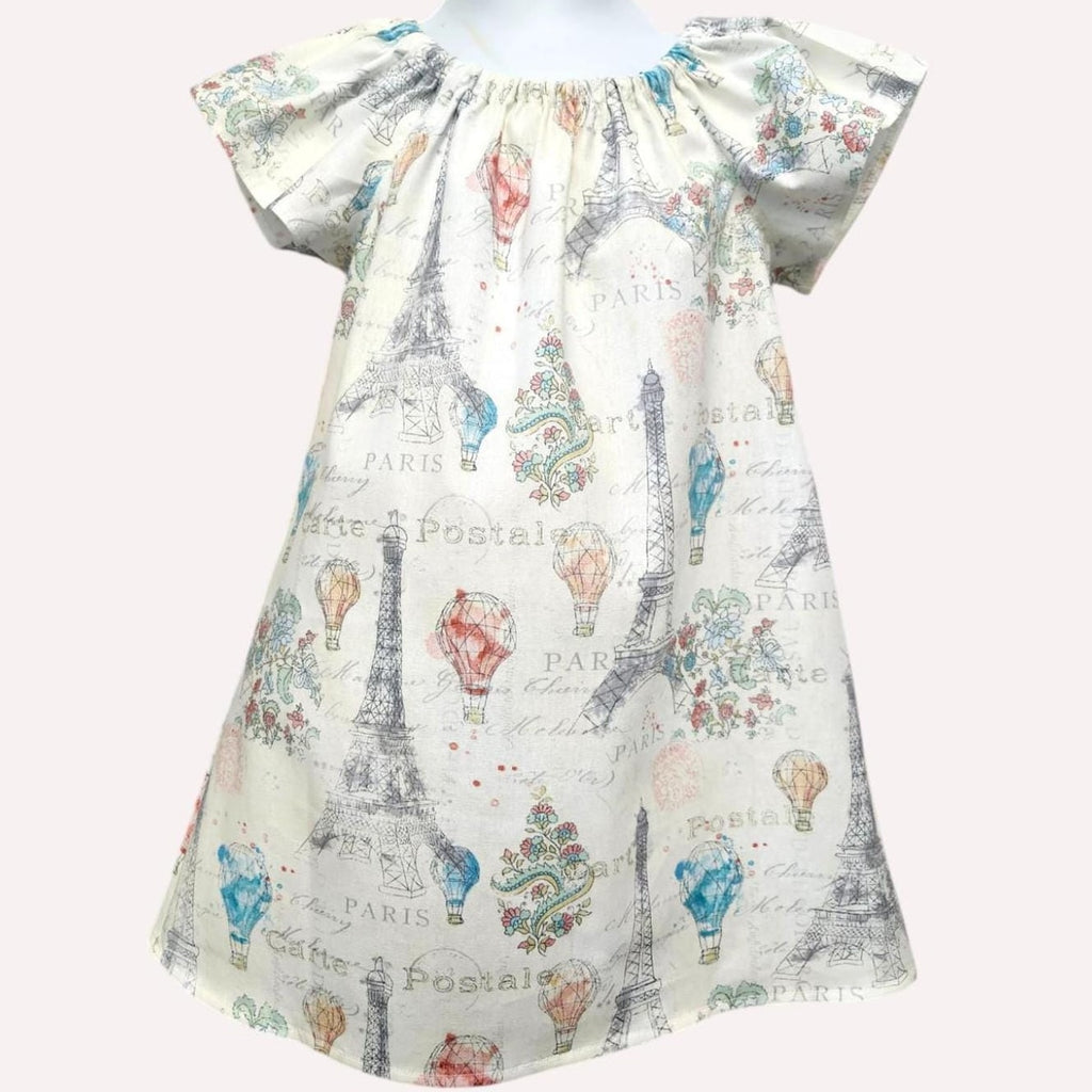 Dress with Paris-themed print featuring Eiffel Tower and hot air balloons on a white background