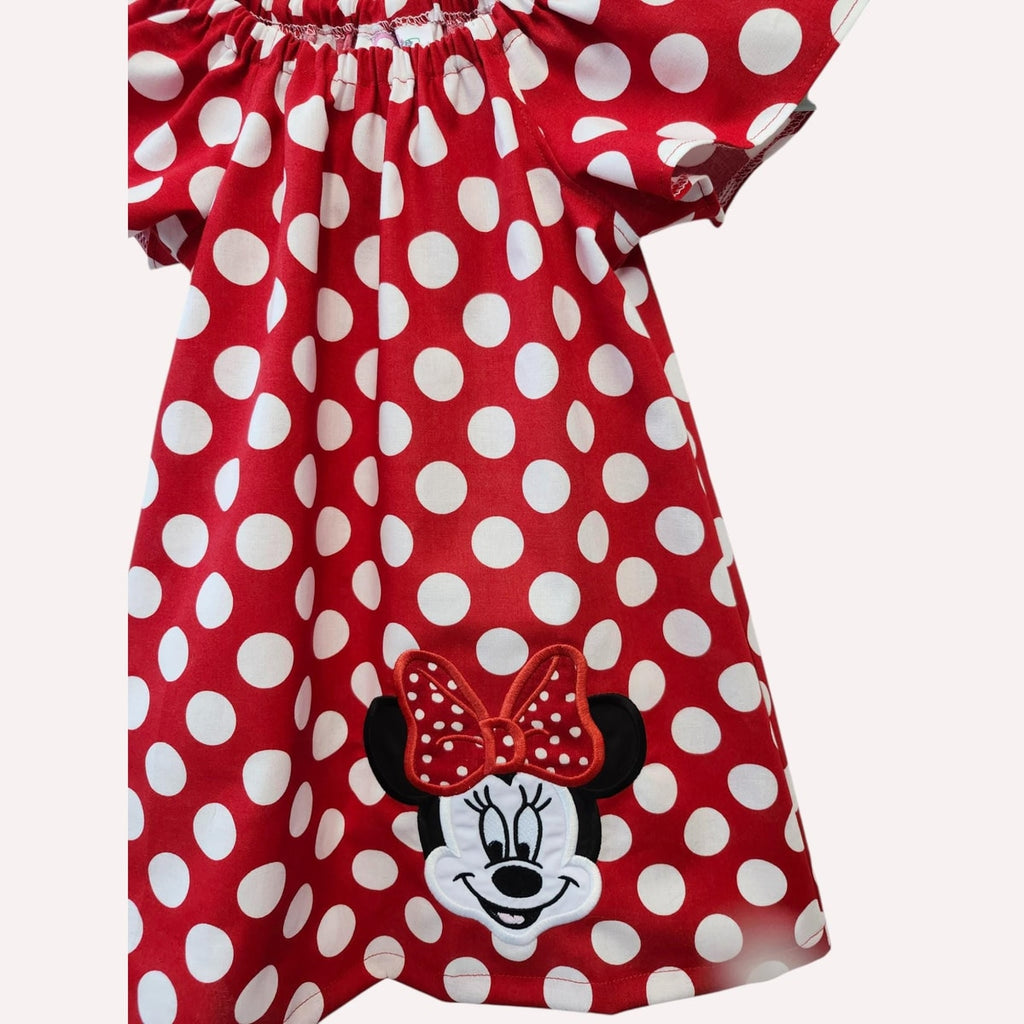 Red polka dot dress with Minnie Mouse face and bow on a white background