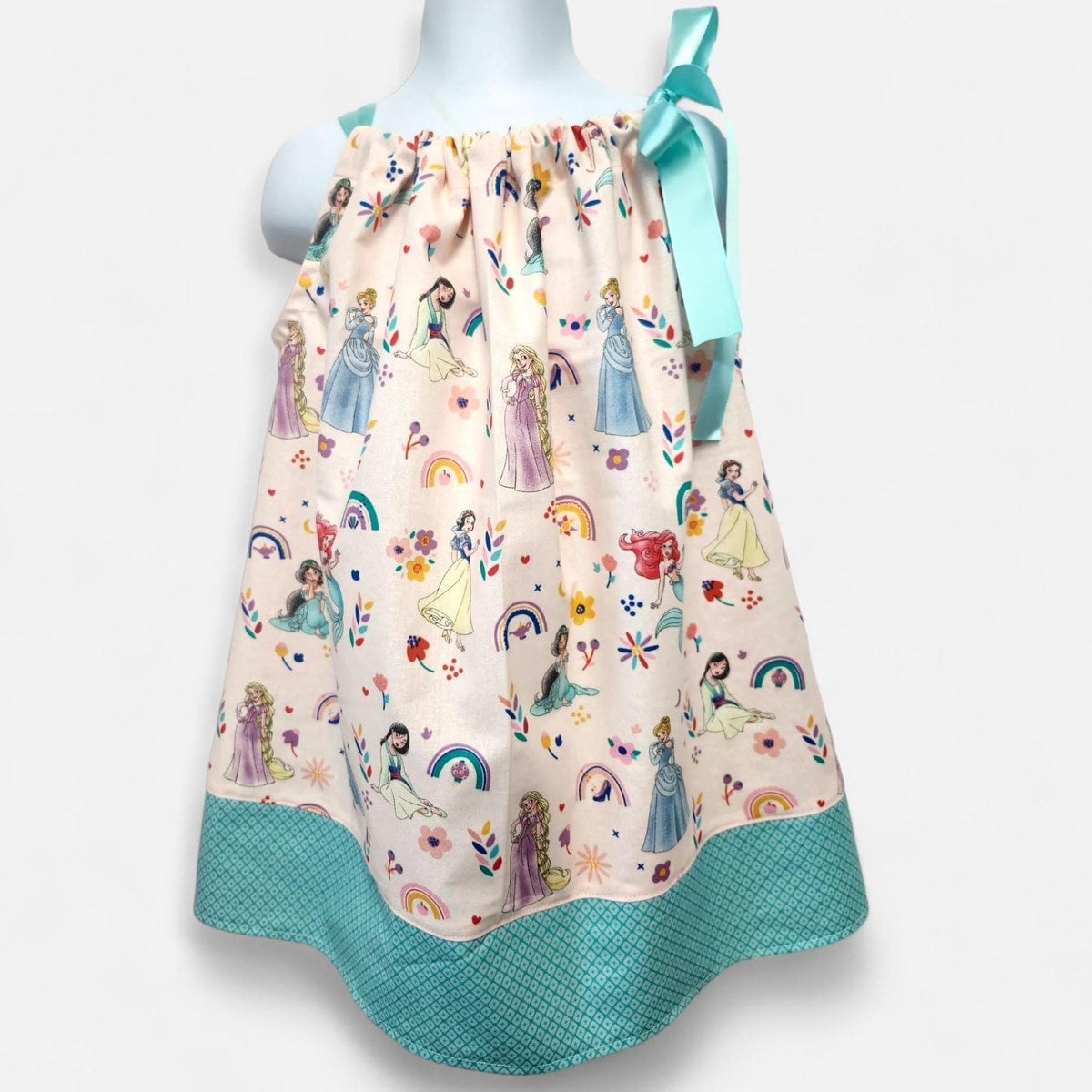 Children's dress with princesses and rainbows on a mannequin against a white background