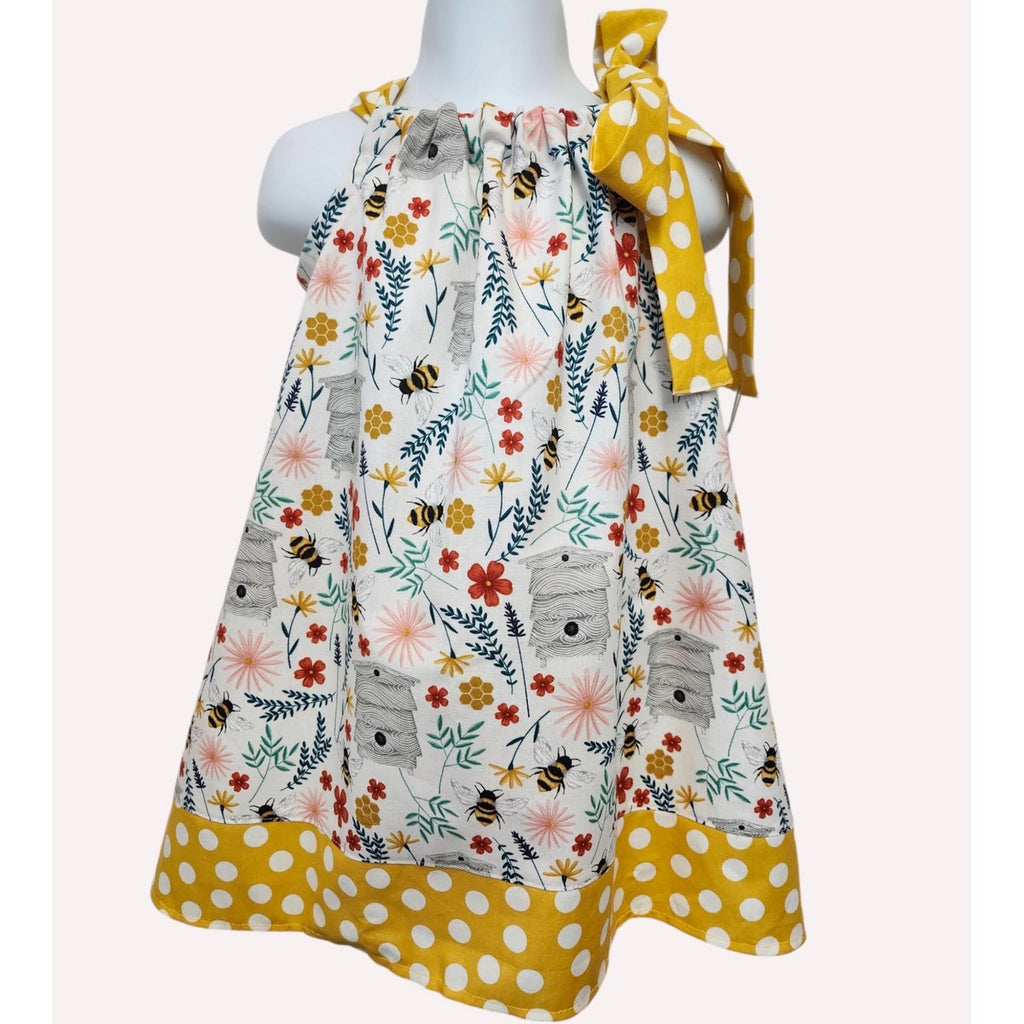 Children's dress with floral and animal pattern on a mannequin against a white background