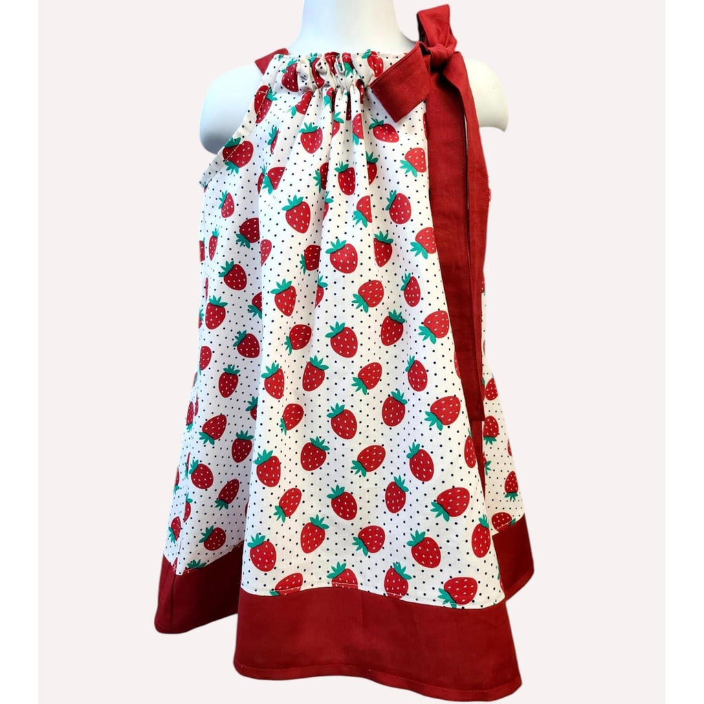 Dress with strawberry pattern and red accents on a mannequin against a white background