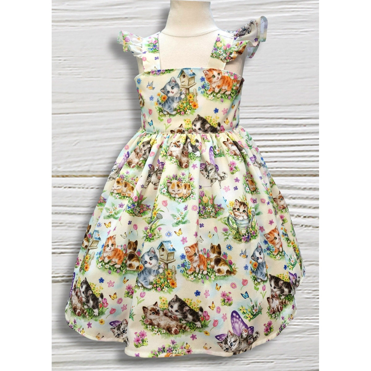 Dress with cat and flower pattern on a mannequin against a white background