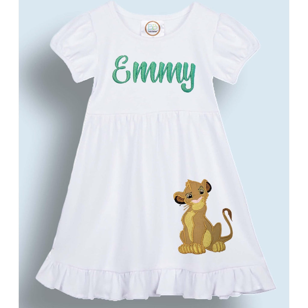 White dress with cartoon lion design and 'Emmy' text on a light blue background