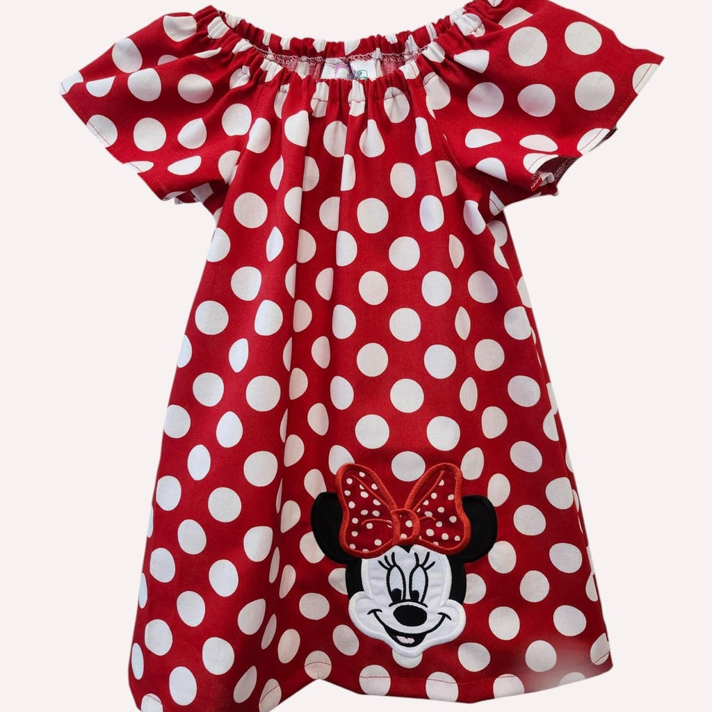 Red polka dot dress with Minnie Mouse face and bow on a white background