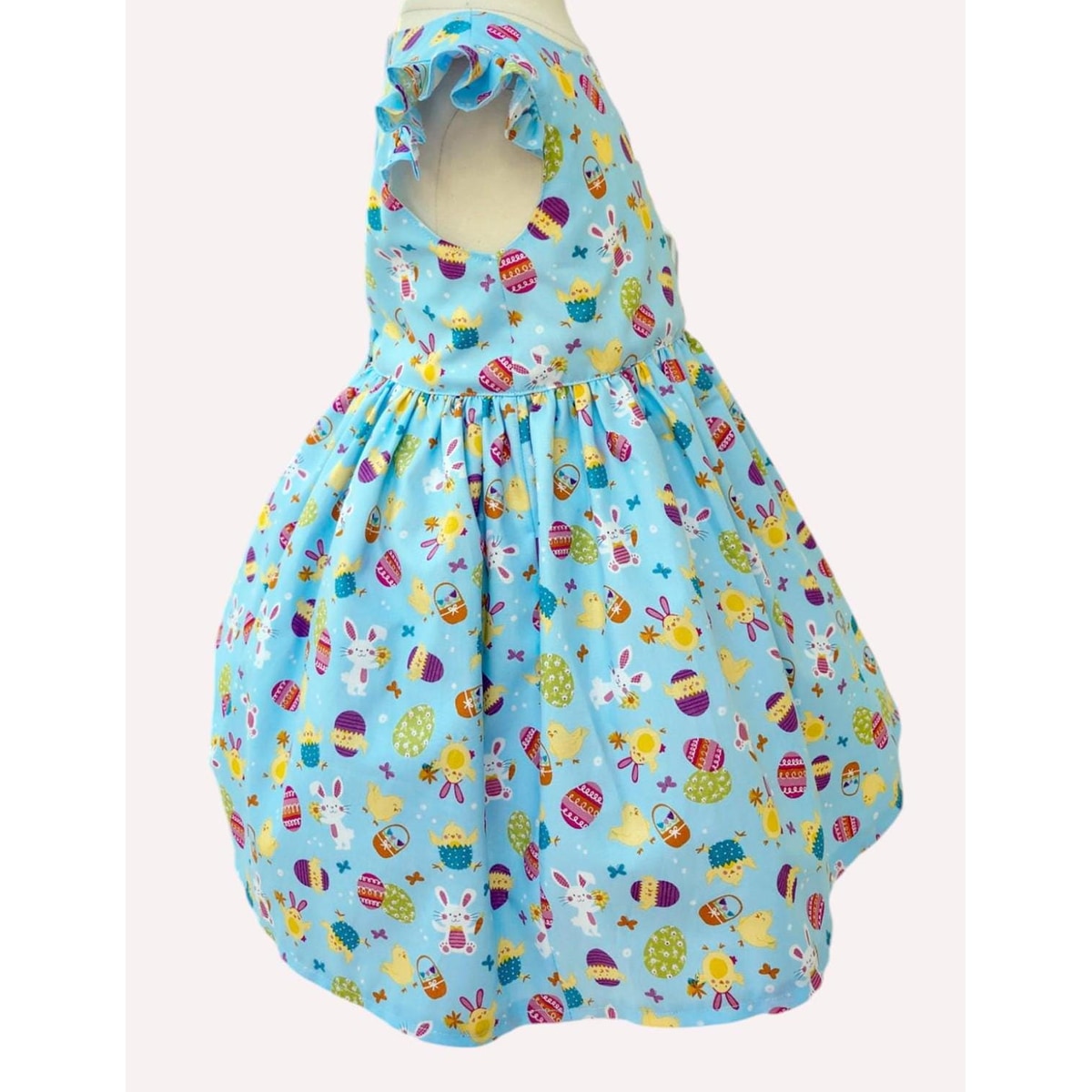 Colorful dress with Easter-themed pattern on a mannequin against a white background