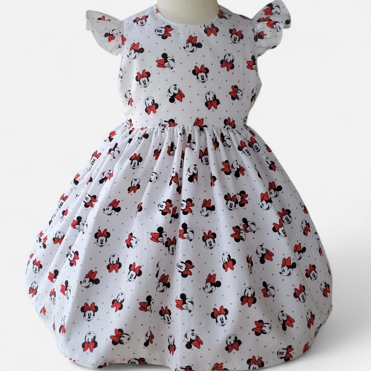 White dress with Minnie Mouse pattern on a white background