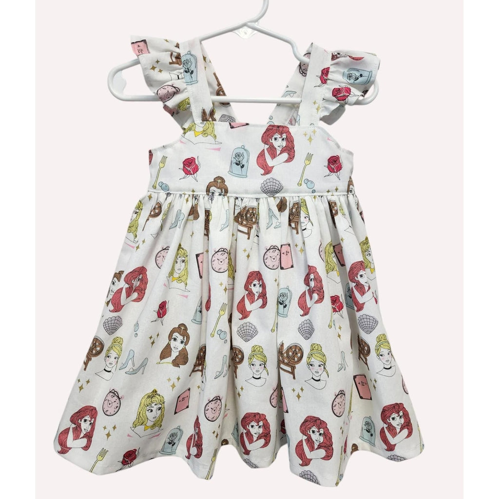 Children's dress with character print on a hanger against a white background