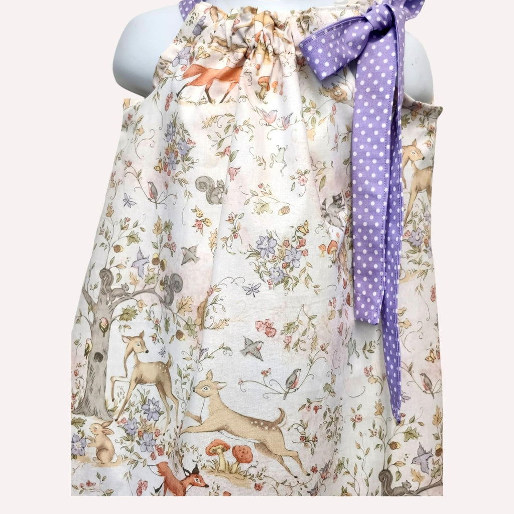 Floral apron with animal prints and a purple ribbon on a mannequin against a white background