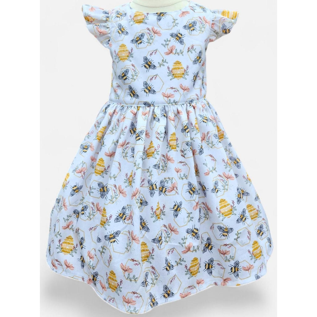 Children's dress with bee and flower pattern on a light blue background