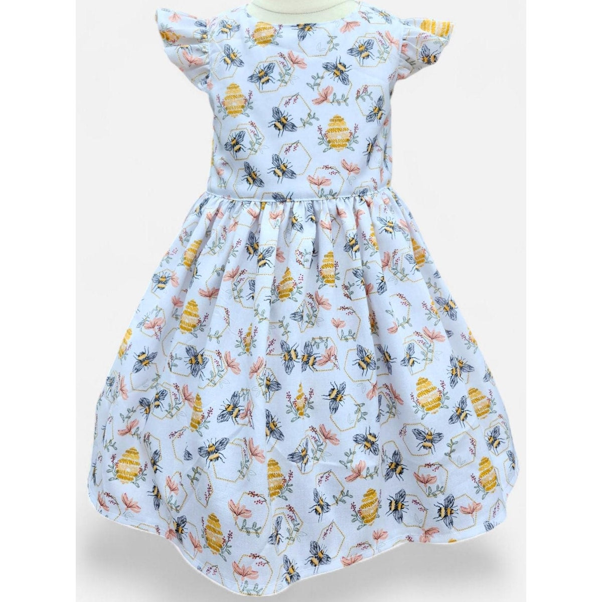 Children's dress with bee and flower pattern on a light blue background