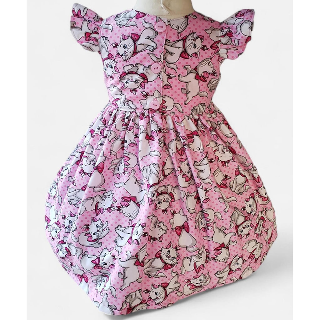 Pink dress with cartoon character pattern on a mannequin against a white background