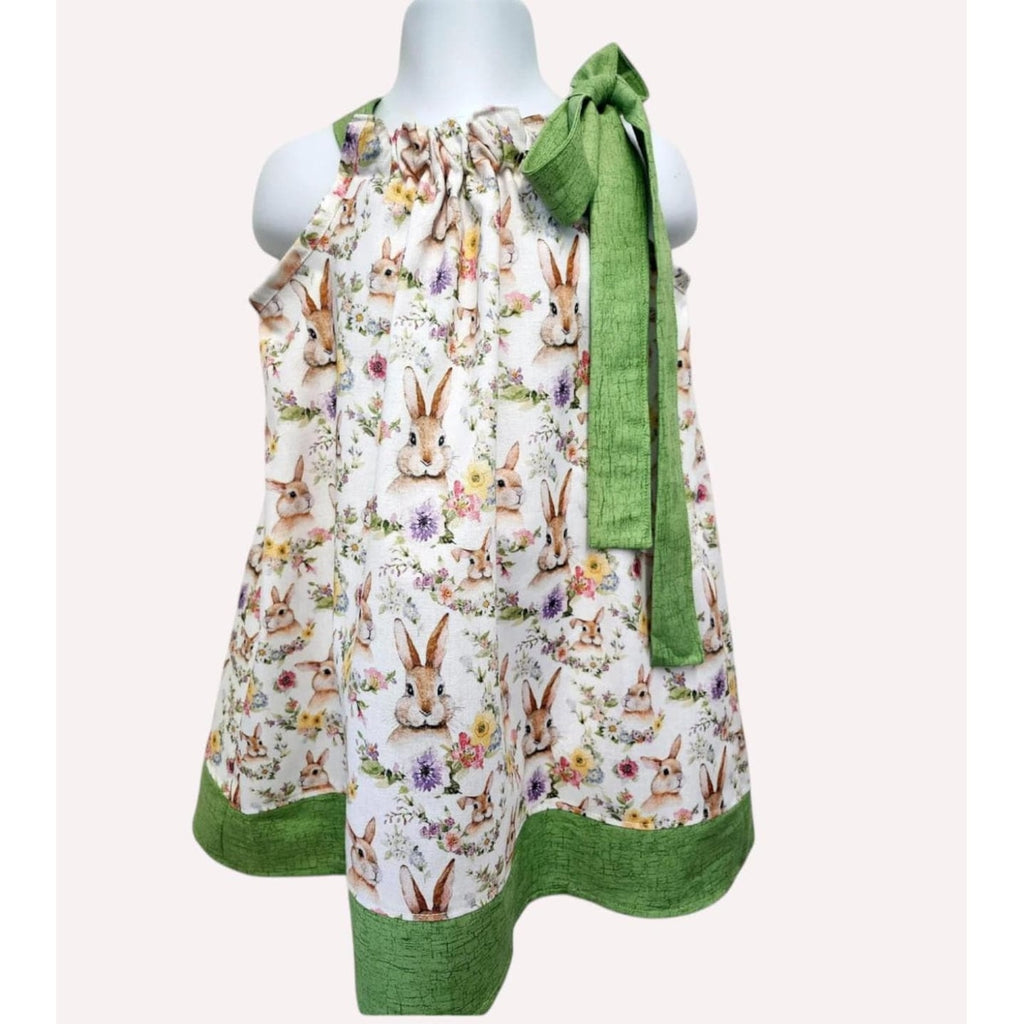 Children's dress with bunny print and green trim on a mannequin against a white background