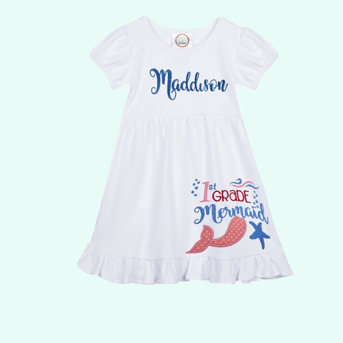 White dress with '1st Grade Mermaid' text and graphics on a light blue background