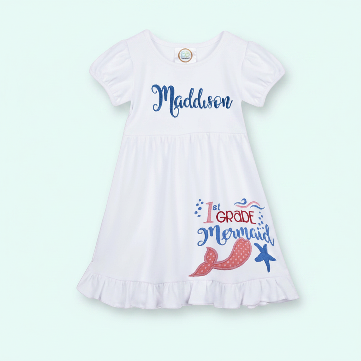 White dress with '1st Grade Mermaid' text and graphics on a light green background