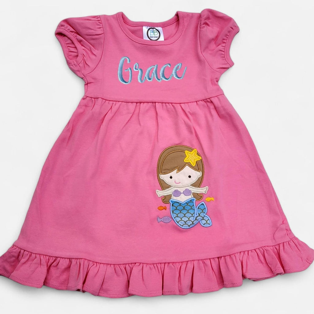 Pink dress with mermaid design and name 'Grace' on a white background