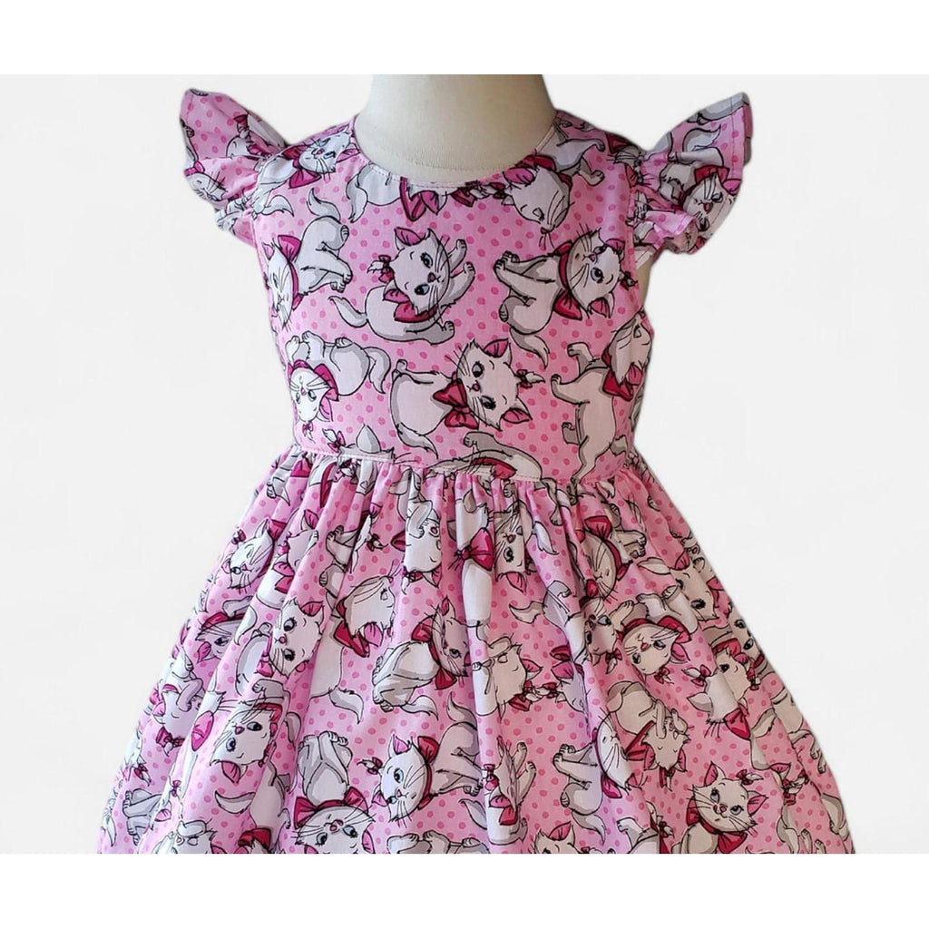 Pink dress with cat pattern on a mannequin against a white background