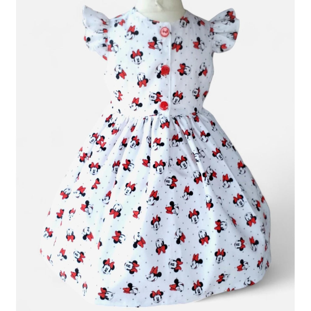 White dress with red and black Minnie Mouse pattern on a white background