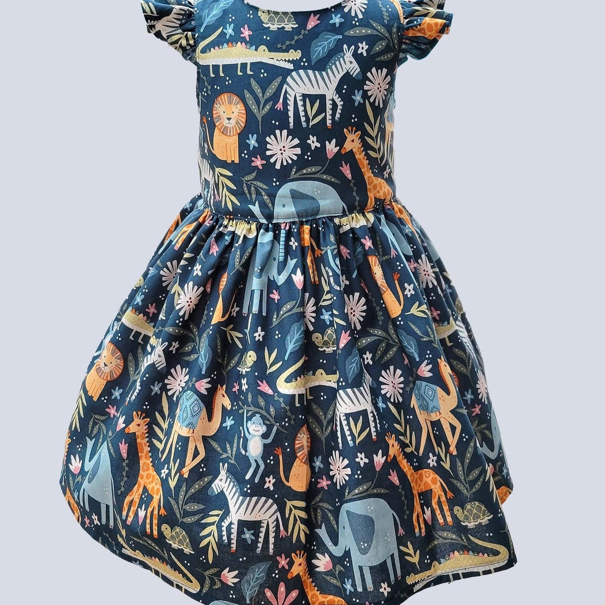 Children's dress with animal pattern on a light gray background