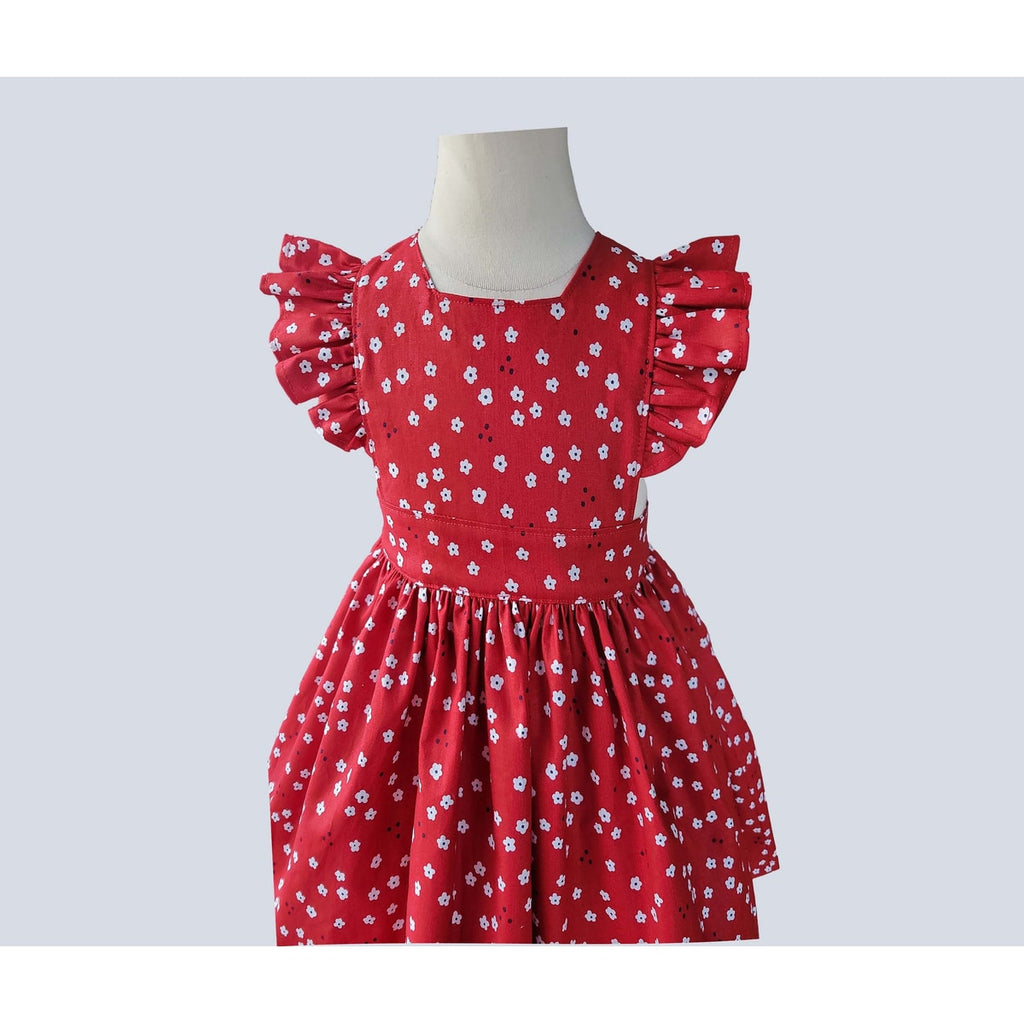 Red dress with white floral pattern on a mannequin against a light gray background