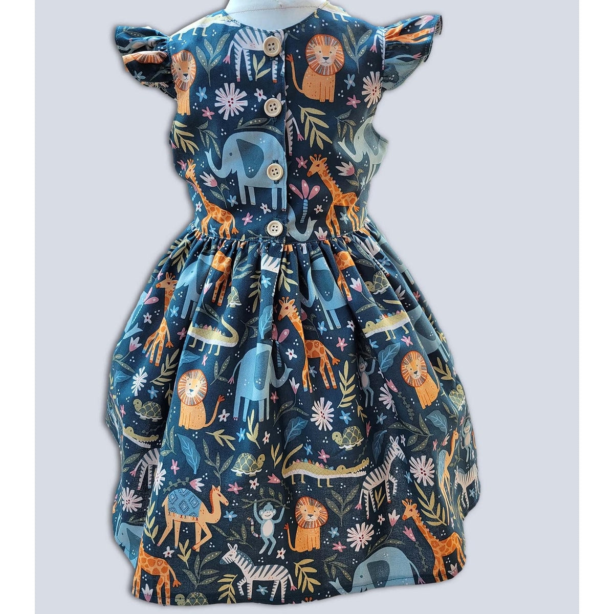 Children's dress with animal pattern on a light gray background