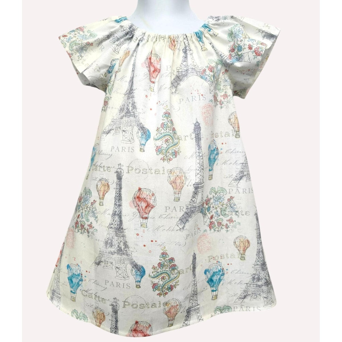 Short-sleeve dress with Paris-themed print on a mannequin against a white background