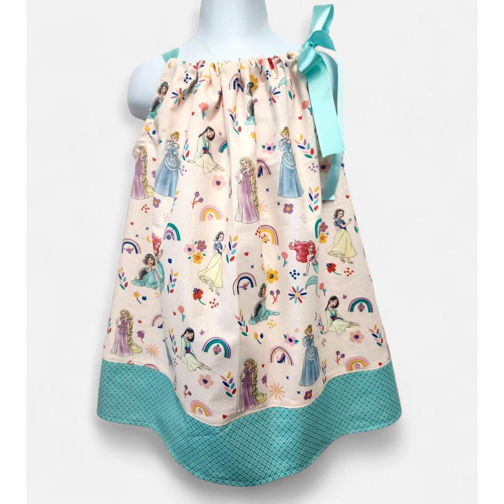 Children's dress with princess pattern and teal accents on a mannequin against a white background