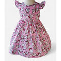 Pink dress with cartoon character pattern on a white background