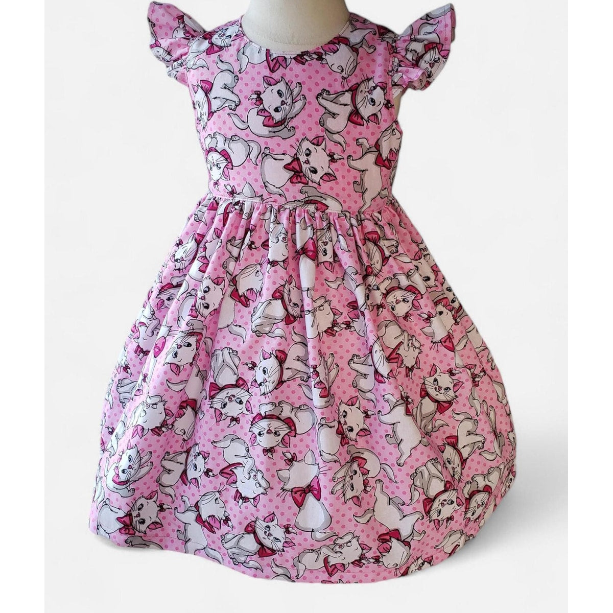 Pink dress with cartoon character pattern on a white background