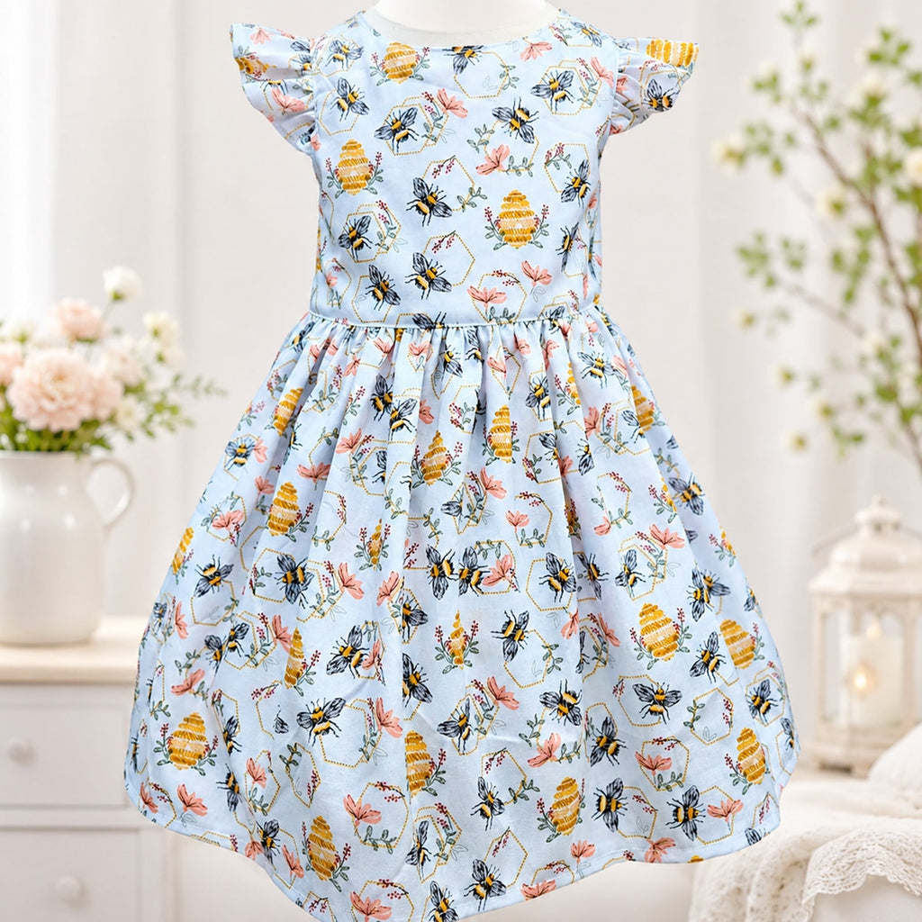 Children's dress with bee and flower pattern on a light blue background