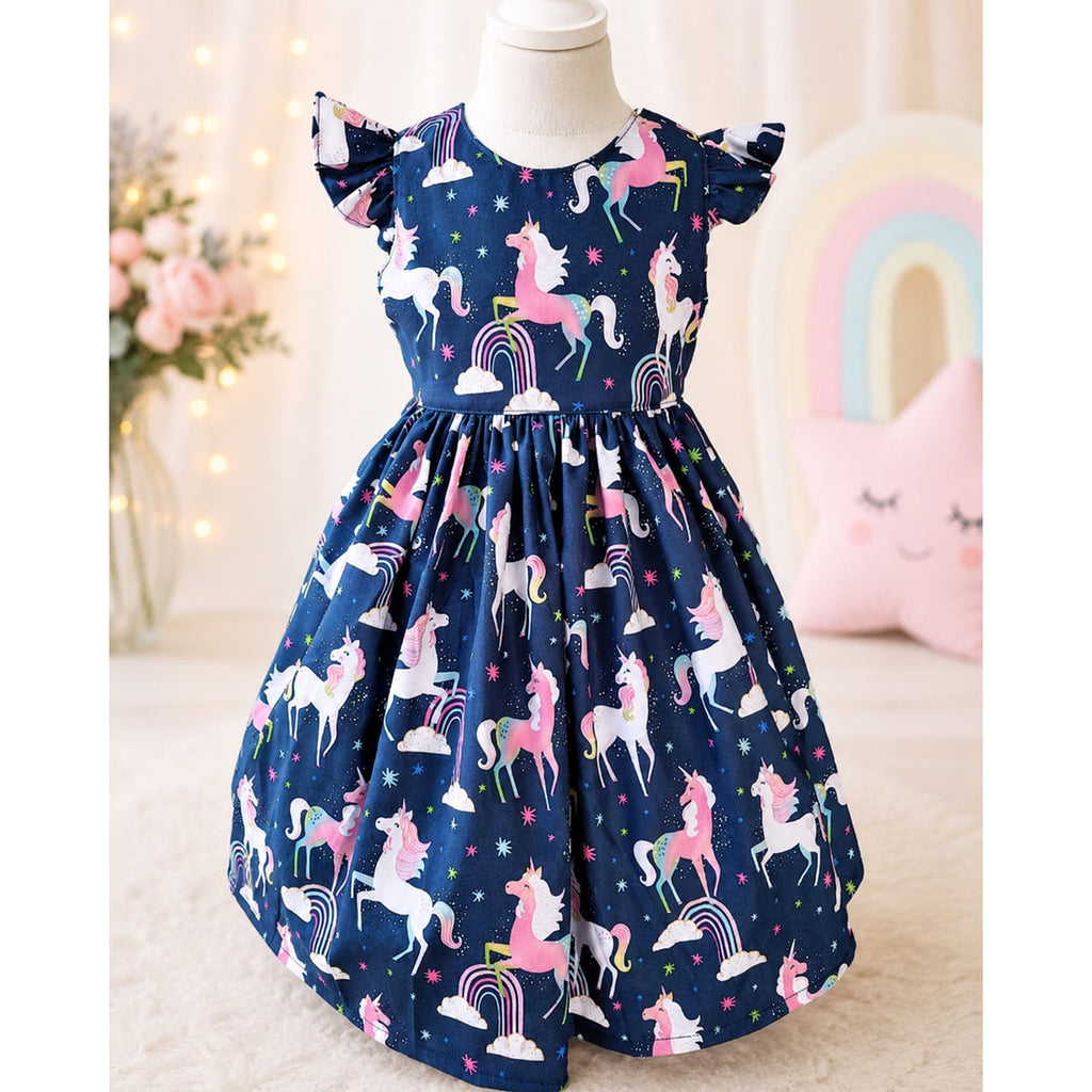Children's dress with unicorn pattern on a mannequin against a soft, blurred background.