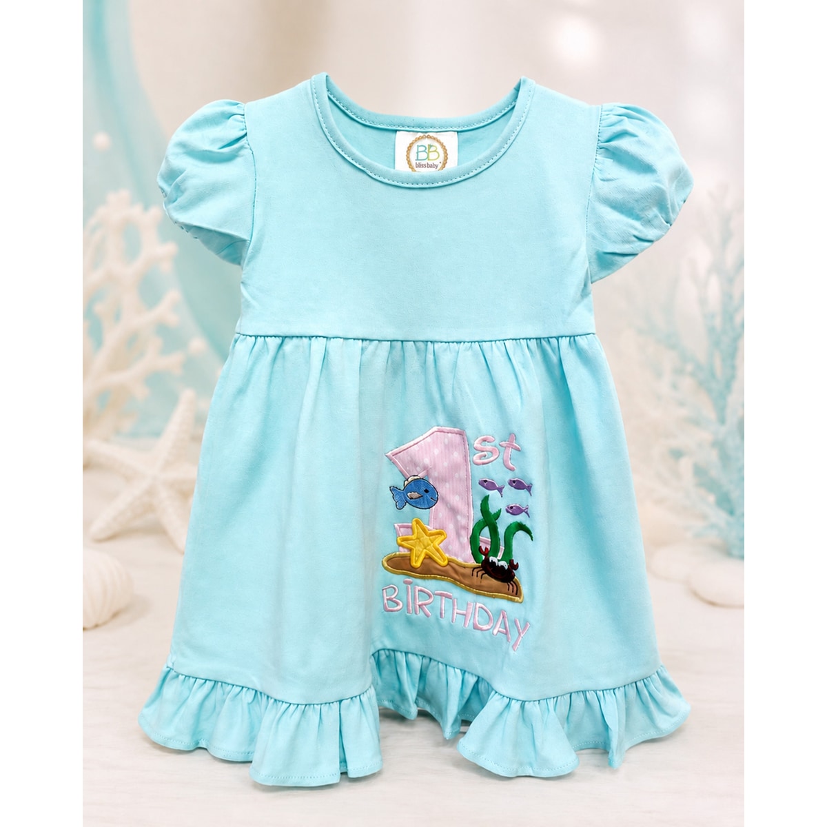 Light blue dress with '1st Birthday' and cartoon character on a neutral background
