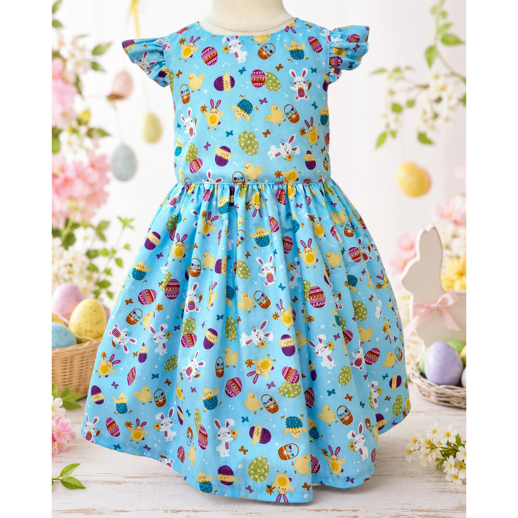 Children's dress with Easter-themed pattern on a mannequin against a floral background