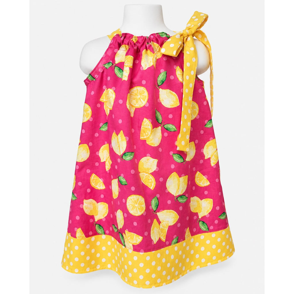 Pink dress with lemon pattern on a mannequin against a white background
