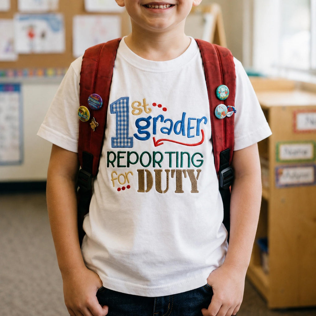 Child wearing a '1st grader reporting for duty' shirt with a red backpack in a classroom setting.
