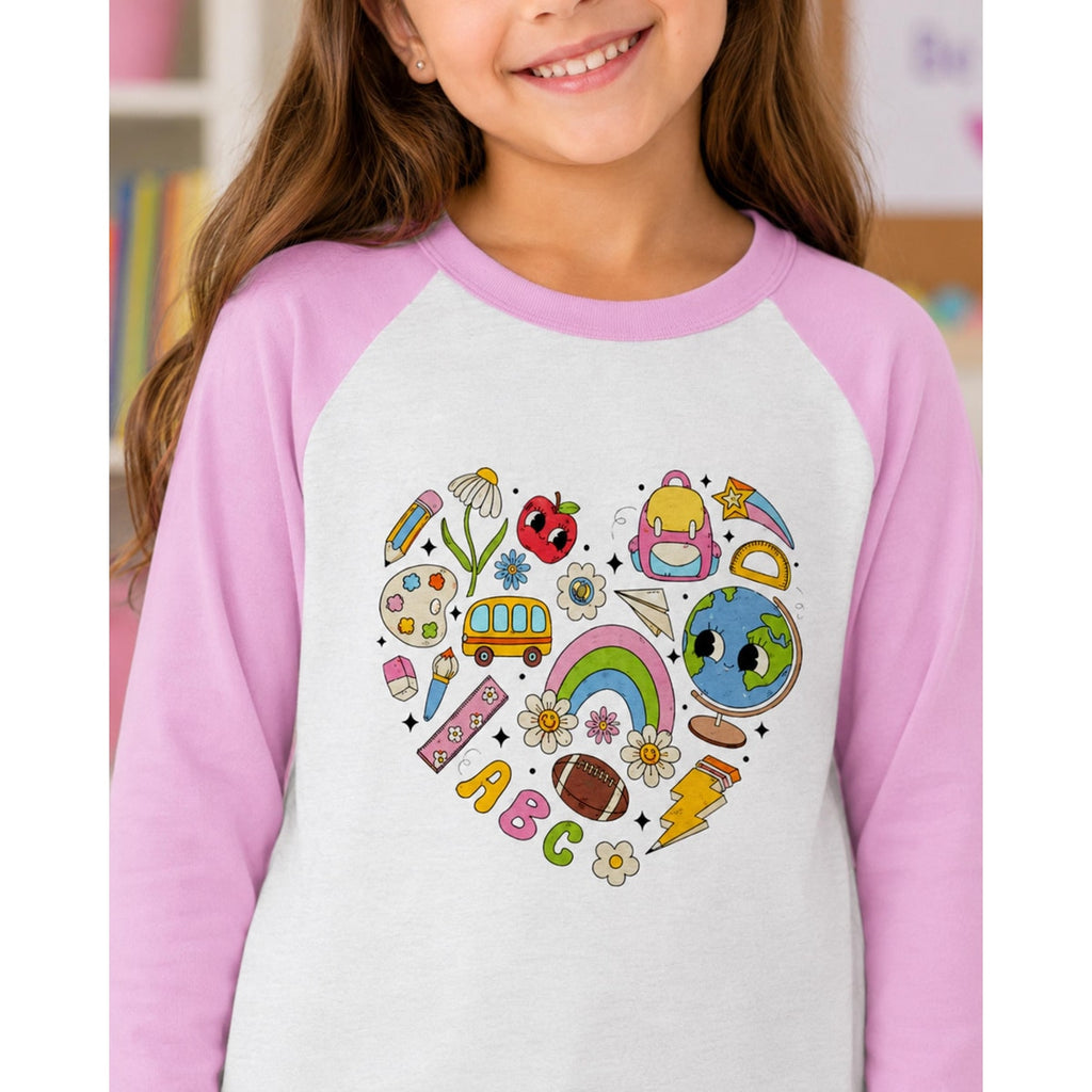 Child wearing a shirt with colorful illustrations on a heart design