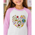 Child wearing a shirt with colorful illustrations on a heart design
