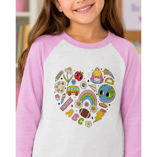 Child wearing a shirt with colorful illustrations on a heart design