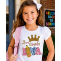 Young girl in a '3rd Grade' shirt with a pink backpack, smiling outdoors.